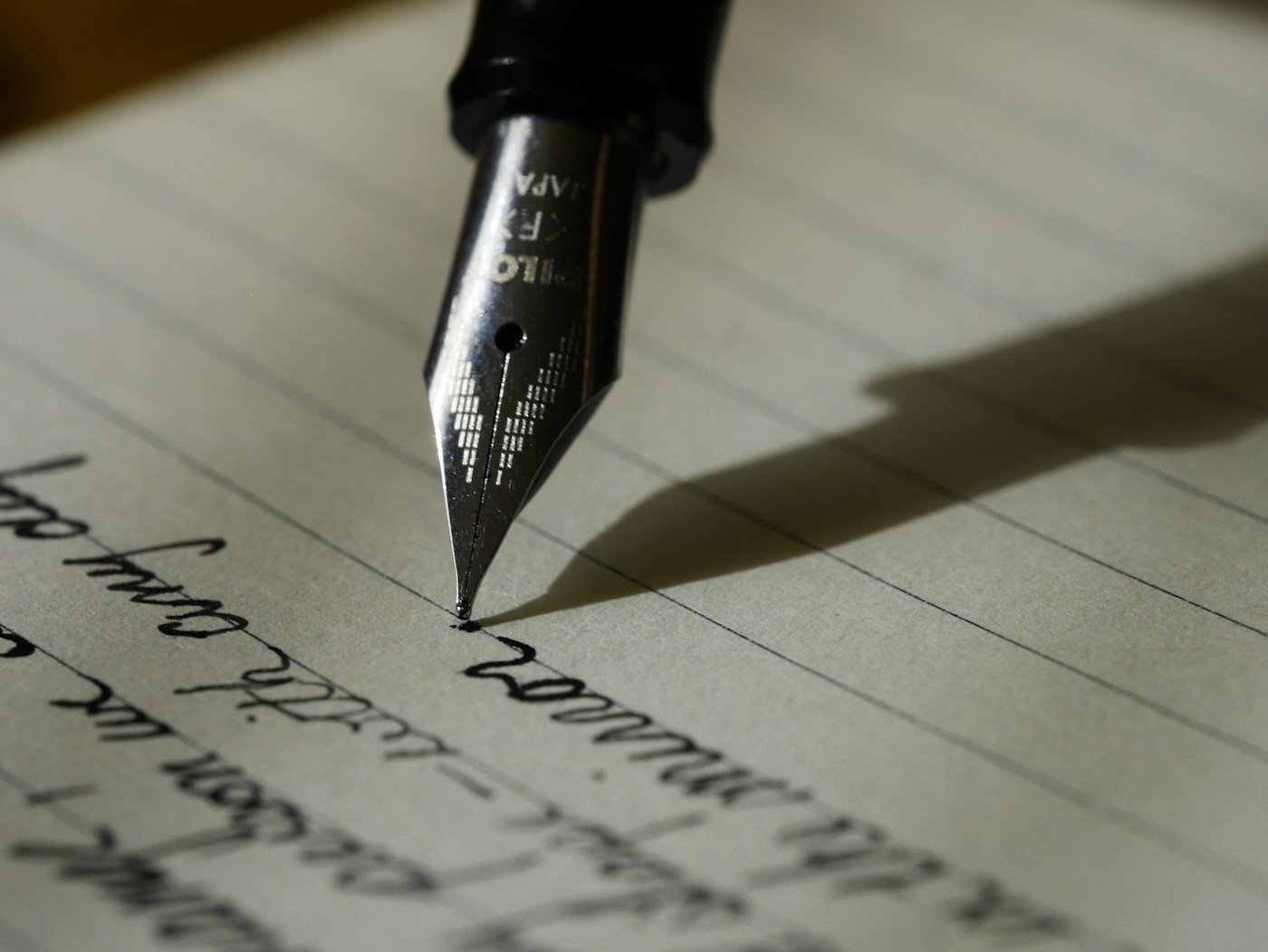 Penna stilografica, taccuino rilegato e calamaio su superficie avorio — still life SayPaper